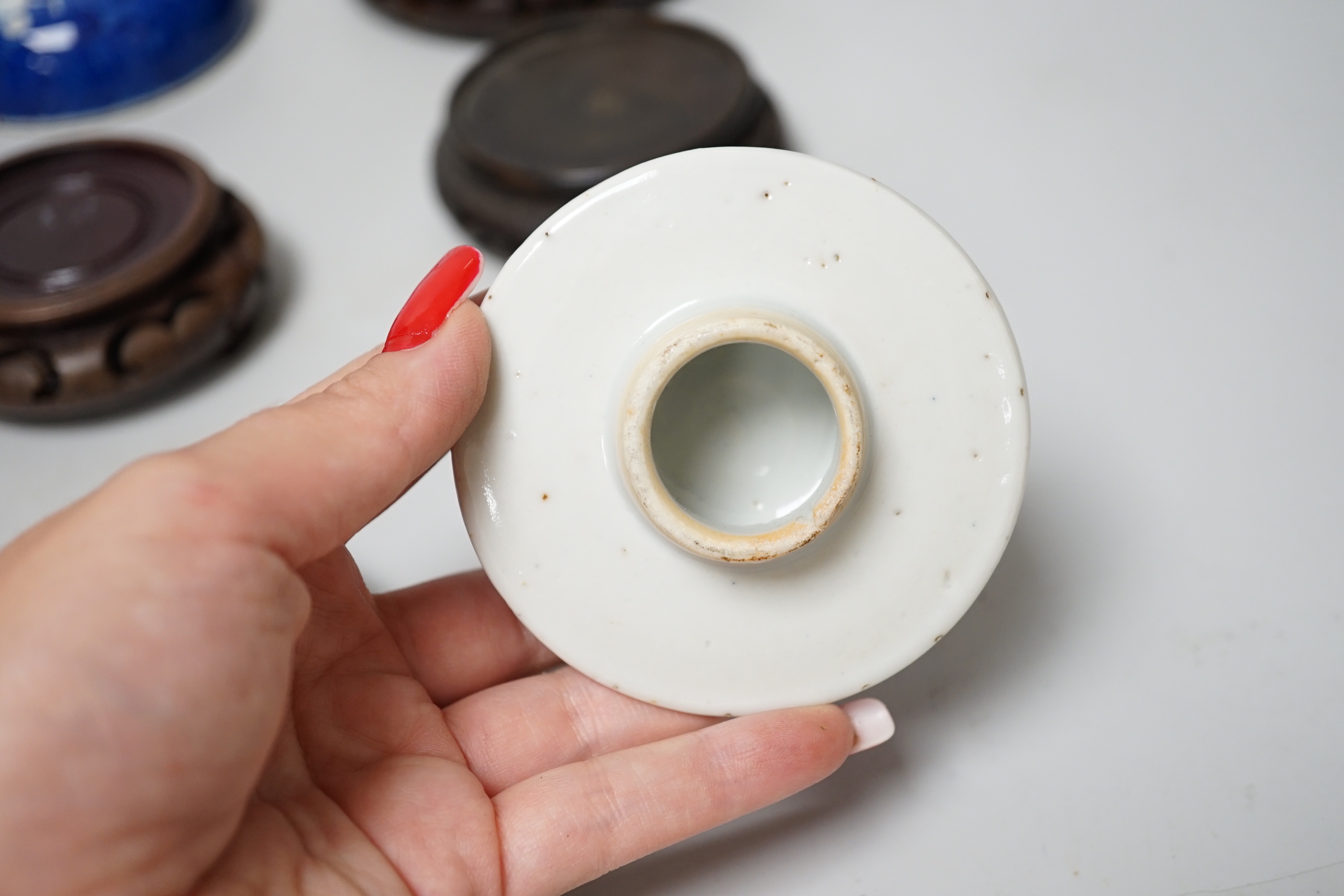 A group of Chinese wooden stands and ceramic lids